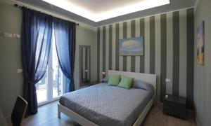 a bedroom with a bed with green pillows and a window at La CASA DEGLI ARTISTI in Tuscania