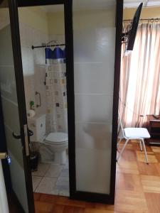 a bathroom with a toilet and a door open at Hostal Estadio Nacional in Santiago