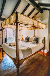 a bedroom with a canopy bed in a room at Bate Papo House Cafe Boutique in Saligao