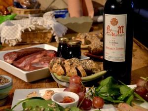 una mesa con una botella de vino y un plato de comida en Chambre d'Hôtes au Domaine du Soleil Couchant, en Saint-André-de-Roquelongue