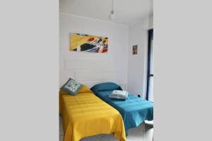 a small room with a bed with a yellow blanket at Langhe&Tartufi, a Ricca di Diano d'Alba in Diano dʼAlba