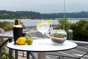 una mesa con una copa de vino y un bol de fruta en Hotel Faro de San Vicente, en San Vicente de la Barquera