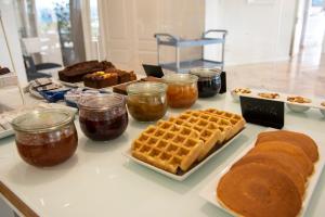 a table with waffles and other desserts on it at Hotel Faro de San Vicente in San Vicente de la Barquera