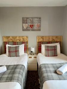 
a hotel room with two beds and two nightstands at Number 19 Guest House in Barrow in Furness
