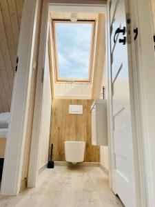 a bathroom with a toilet and a window at Czerwony Domek in Sasino