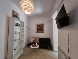 sala de estar con sofá negro y TV en Apartments Lav en Umag