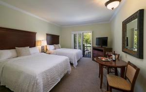 
a hotel room with two beds and a television at Paso Robles Inn in Paso Robles
