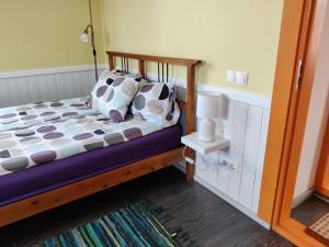 1 dormitorio con cama de madera y almohadas en Promenādes apartamenti, en Ventspils