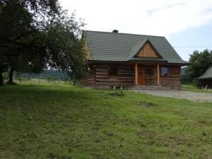 a log cabin in a field next to a tree at Serce Beskidu Niskiego Myscowa in Krempna