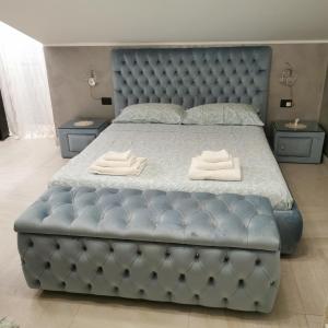 a large bed with a blue tufted bed frame at Residence Villa candida in Giardini Naxos