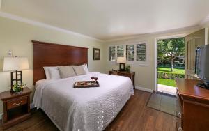 a bedroom with a bed with a tray of food on it at Paso Robles Inn in Paso Robles