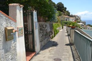 a gate on a stone wall next to a sidewalk at Casa Vacanze Bouganvillea in Cetara