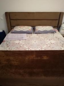 1 cama con cabecero de madera y 2 almohadas en Lux apartment, near metro Vasylkivska, en Kiev