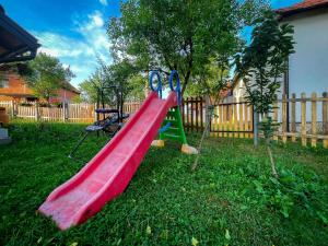 a playground with a red slide in a yard at Vikendica Kostic in Zlatibor