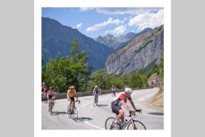 a group of people riding bikes down a road at L'edelweis in Le Bourg-dʼOisans