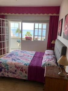 1 dormitorio con cama y vistas al océano en Chaparil, en Nerja
