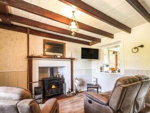 a living room with a fireplace and a couch and chairs at 8 Achnabat in Thurso
