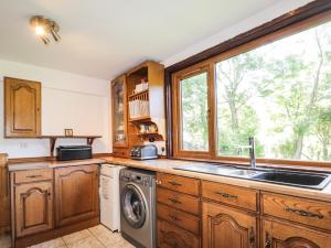 een keuken met een wastafel en een wasmachine bij 8 Achnabat in Thurso