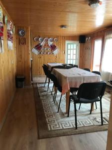 Pensiunea Grapini في Şanţ: غرفة طعام مع طاولة وكراسي طويلة