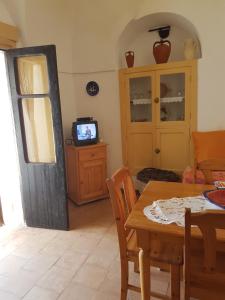 une salle à manger avec une table et une télévision dans l'établissement dammusi, à Pantelleria