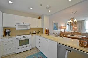 a kitchen with white cabinets and a stove top oven at Harbor Villa Club 206 in Longboat Key