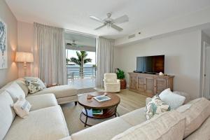 a living room with two white couches and a television at Harbor Villa Club 206 in Longboat Key
