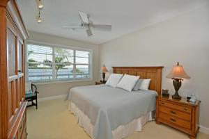 a bedroom with a bed with a ceiling fan and a window at Harbor Villa Club 206 in Longboat Key +14 photos