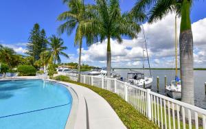 a swimming pool next to a marina with boats at Harbor Villa Club 206 in Longboat Key