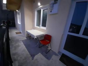 Habitación con mesa blanca y silla roja en Apartments "La Štabe" - Kruševo en Kruševo