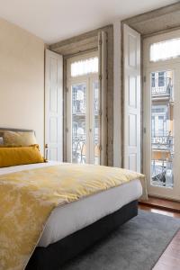 a bedroom with a large bed and two windows at Impar luxury residence in Porto