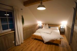 a bedroom with a bed with white sheets and two lamps at Chalet - Apartment - Mit Liebe dekoriert in Öblarn