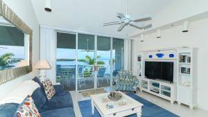uma sala de estar com um sofá azul e uma televisão em Harbor Villa Club 309 em Longboat Key