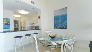 a dining room with a glass table and chairs at Harbor Villa Club 309 in Longboat Key