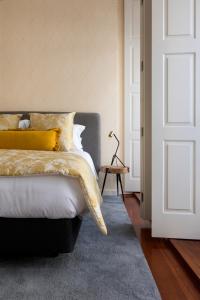 a bedroom with a bed with yellow pillows at Impar luxury residence in Porto