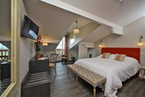 Schlafzimmer mit einem großen Bett mit einem roten Kopfteil in der Unterkunft Hotel Agian in Itxassou