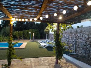 pergola z krzesłami i basenem w obiekcie Vivienda Rural Maestro Herrador w mieście Ubrique