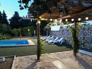 pergola z leżakami i basenem w obiekcie Vivienda Rural Maestro Herrador w mieście Ubrique