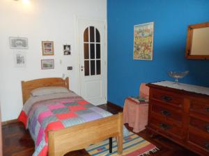 1 dormitorio con 1 cama, vestidor y paredes azules en Alle Terrazze del Borgo Vecchio, en Palermo
