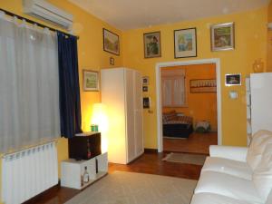 a living room with yellow walls and a white couch at Alle Terrazze del Borgo Vecchio in Palermo