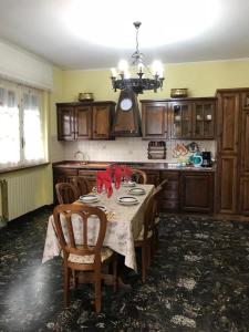 a kitchen with a table with chairs and a chandelier at VILLA FELICE in Loano