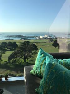 a couch sitting in front of a window with a view at Incomparable Vista al Golf in Mar del Plata
