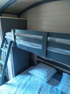 two bunk beds in a room with a bed at La Roulotte de Francine in Chazeuil