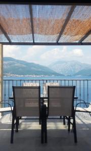 two chairs on a balcony with a view of the water at Martin Lux Apartment in Krasici