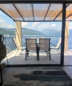 eine Terrasse mit einem Tisch und Stühlen auf dem Balkon in der Unterkunft Martin Lux Apartment in Krasići