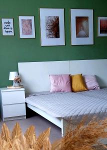 a bedroom with a bed and a green wall at New Life Apartment in Latschach ober dem Faakersee
