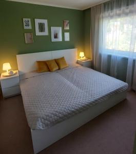 a bedroom with a bed with yellow pillows and a window at New Life Apartment in Latschach ober dem Faakersee