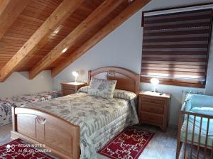 a bedroom with two beds and wooden ceilings at Casa Rural Las Mestas in Cangas del Narcea