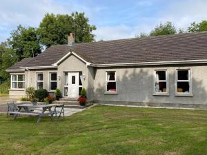 a house with a picnic table in front of it at Orchard Lodge in Glenavy