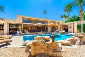 a home with a swimming pool and a house at Rancho Mirage Tamarisk Villa in Rancho Mirage