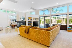 a living room with a yellow couch and a fireplace at Rancho Mirage Tamarisk Villa in Rancho Mirage